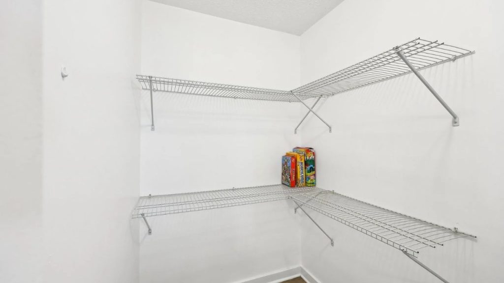 Small pantry with white wire shelves and a few board games stacked on the lower level.