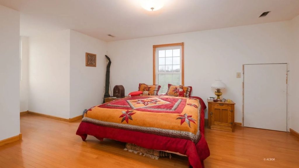 A cozy bedroom with wooden floors, a colorful quilt, and a warm, inviting ambiance.