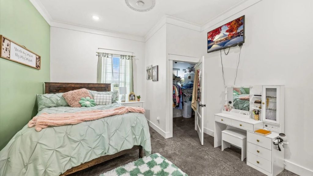 Charming bedroom with pastel decor, a vanity, and a walk-in closet.