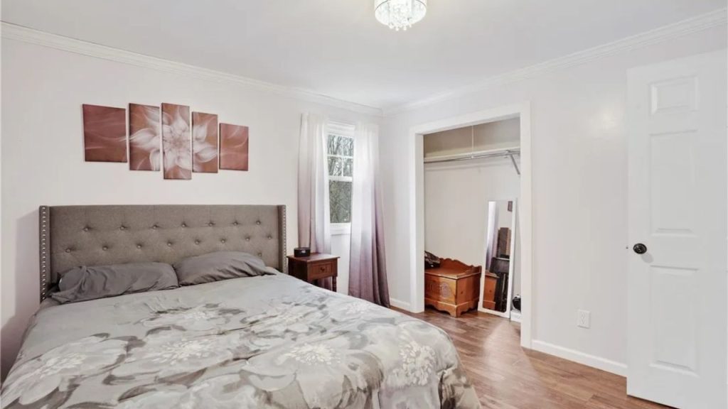 Minimal bedroom with a tufted bed, soft tones, and open closet space.