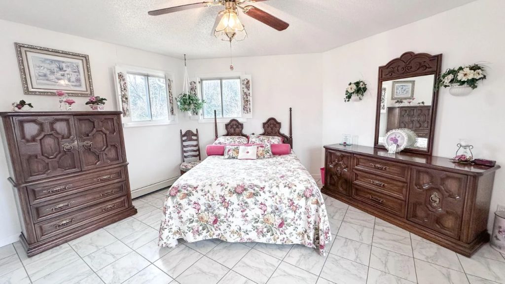 Bright bedroom with dark wood furniture and floral bedding.