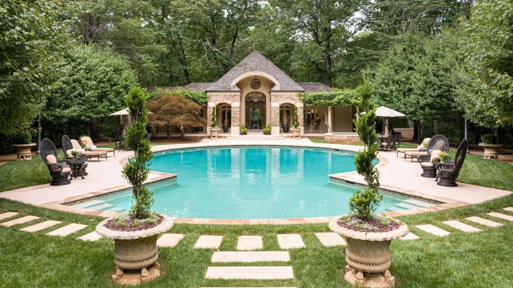 Tranquil poolside retreat with a villa and lush greenery.