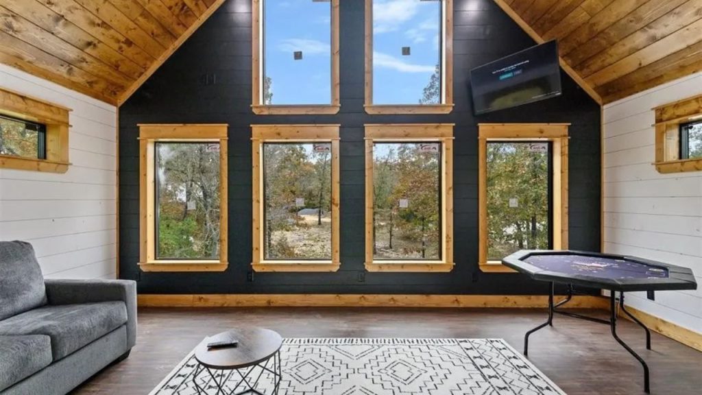 Game room with large windows, wood ceiling, and poker table.