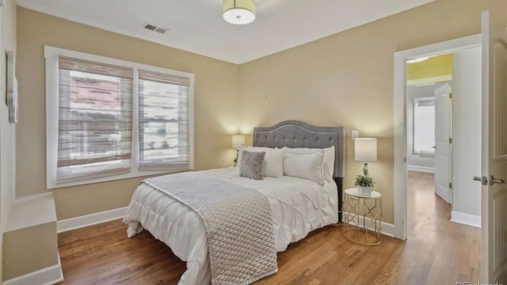 Cozy bedroom with soft lighting and tufted gray headboard.