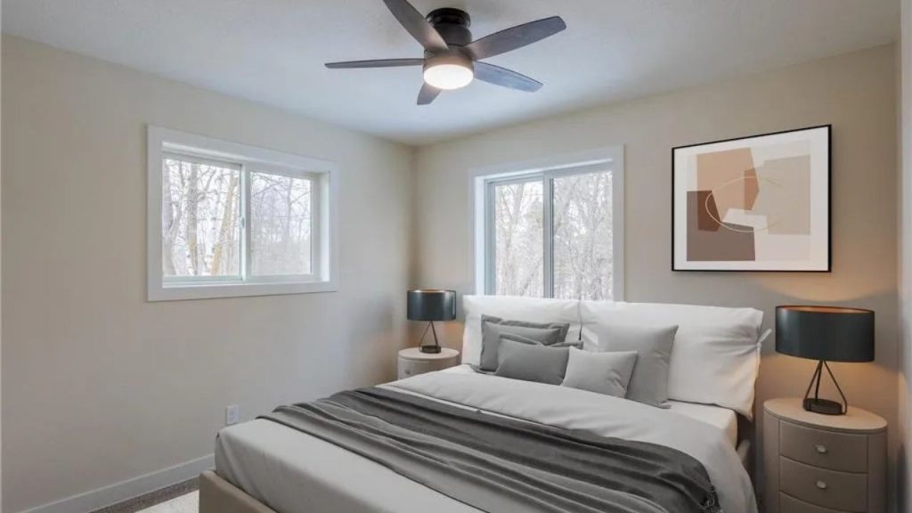 Minimal bedroom with two windows, neutral bedding, and modern ceiling fan.