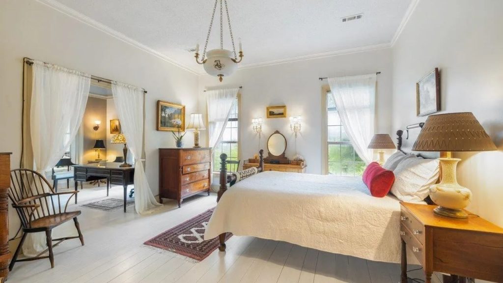 Light-filled bedroom with vintage furniture and farmhouse charm.
