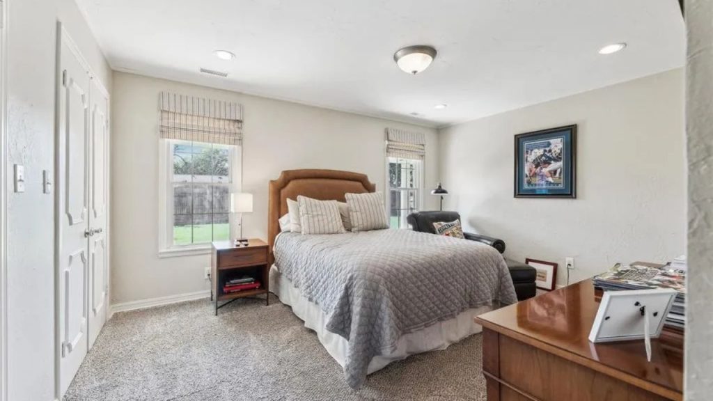Inviting bedroom with gray bedding, brown headboard, and relaxed decor.