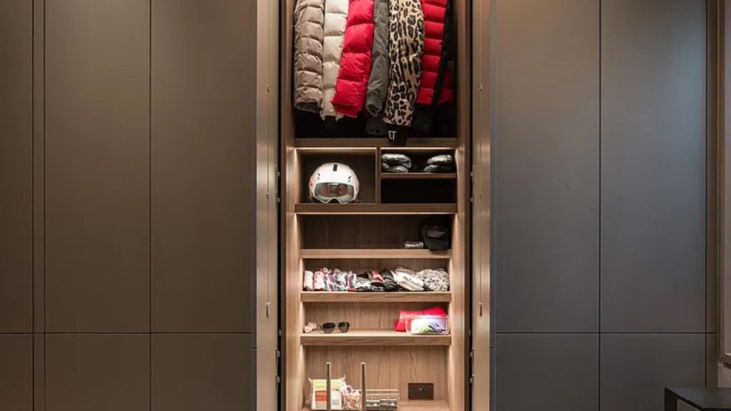 Modern closet with winter jackets and ski gear neatly arranged.