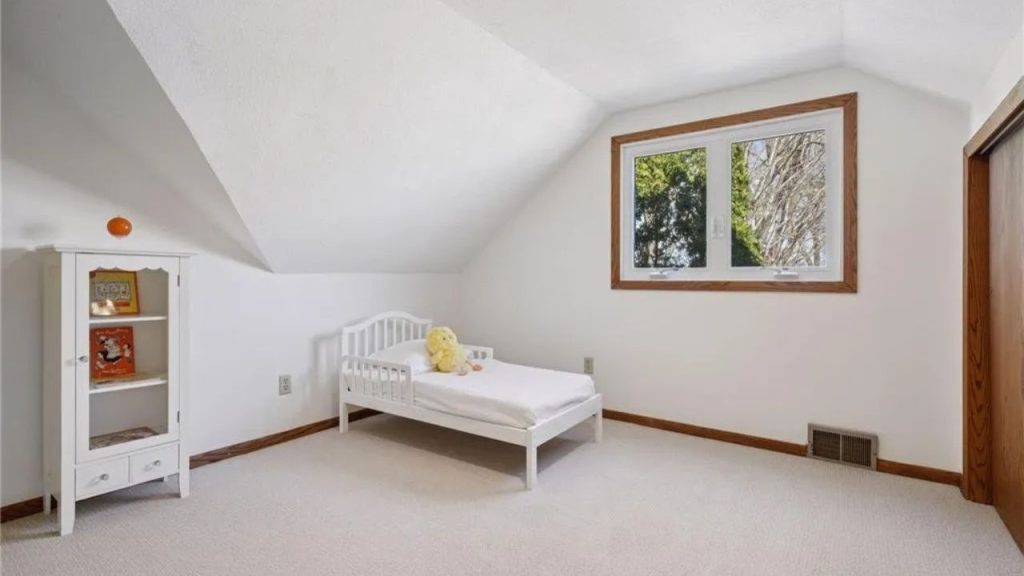 Sweet attic bedroom with a toddler bed and soft lighting.