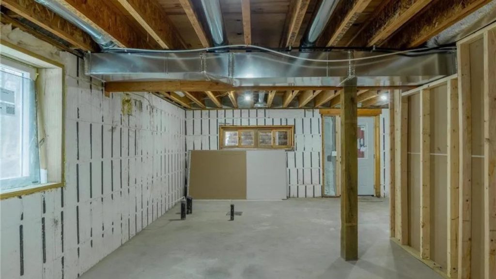 Unfinished basement with exposed beams, ductwork, and plumbing rough-ins.