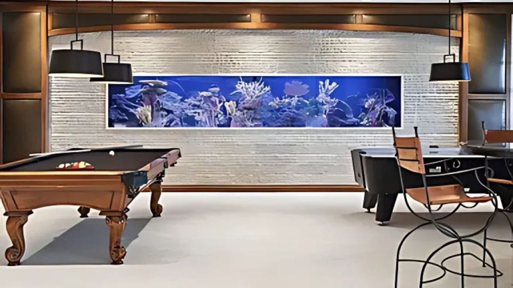 Game room with pool table and built-in wall aquarium.