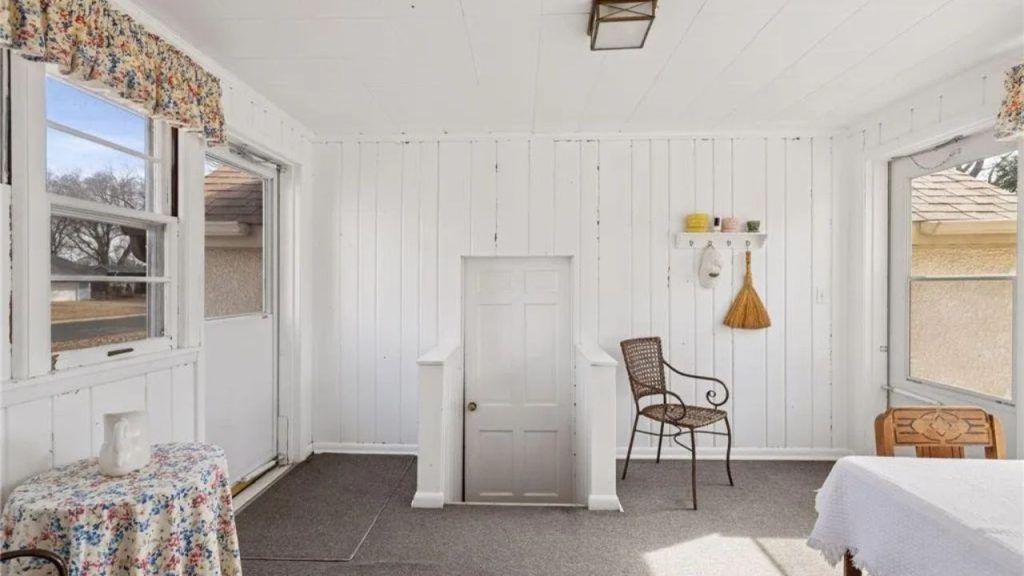 Cozy white sunroom with vintage charm and natural light.