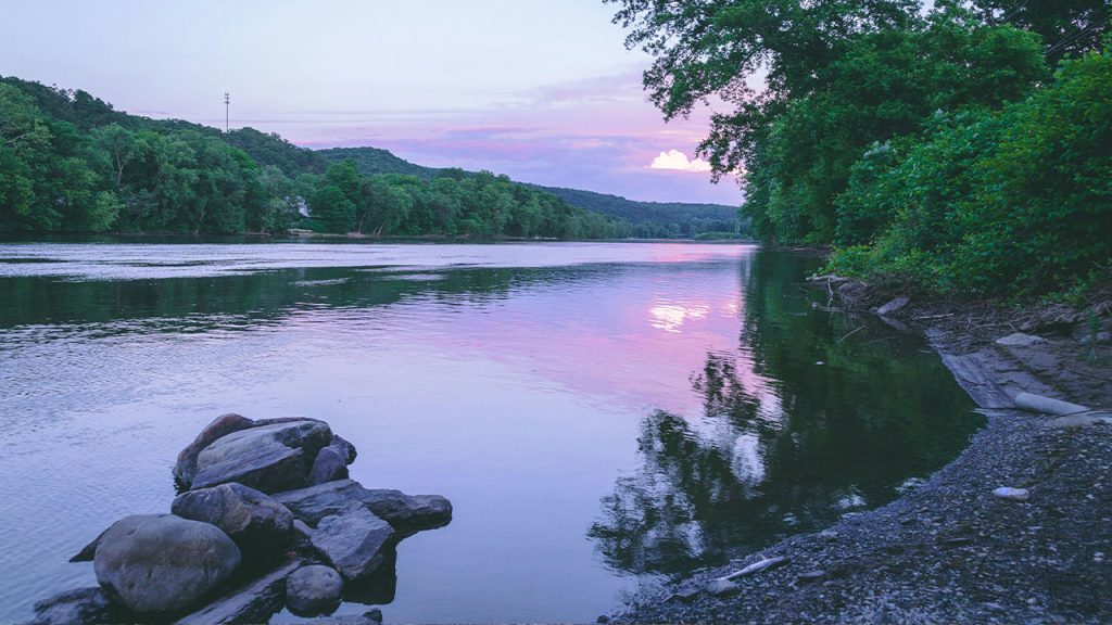 Calm Body of Water Near Rocks and Trees during Day