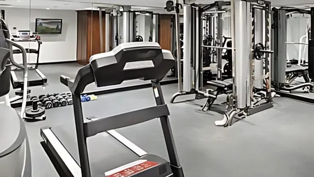 Modern home gym with treadmill and strength training equipment.