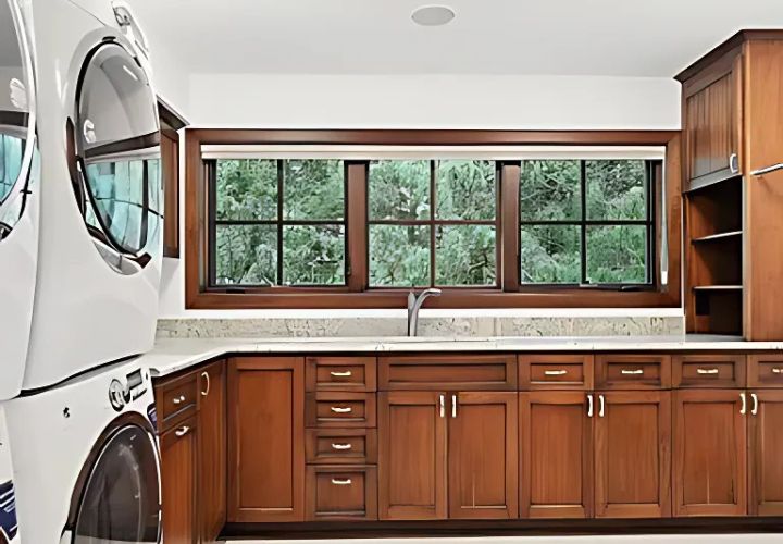 Laundry room with wood cabinets, large window, and stacked washer-dryer.