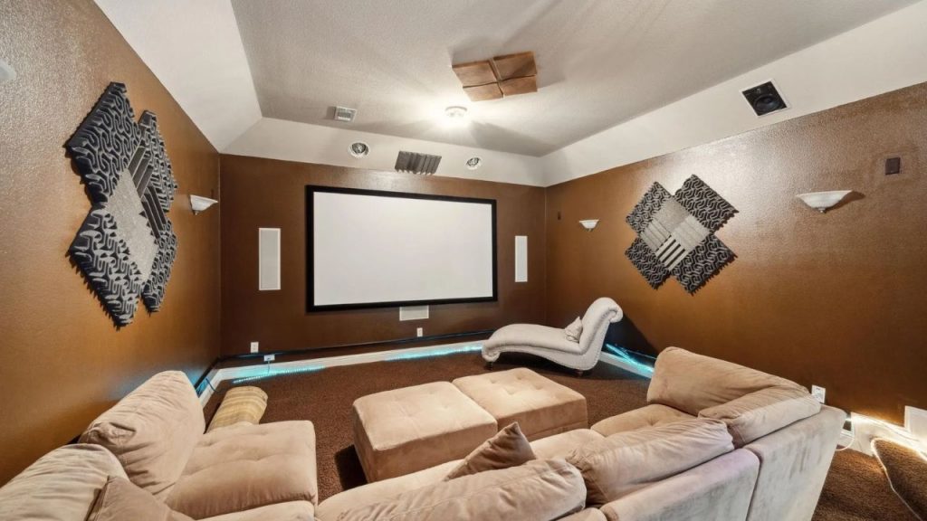 Home theater with brown walls, comfy seating, and wall-mounted acoustic panels.