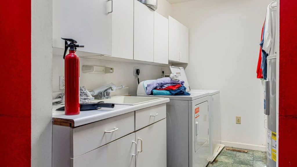 Simple laundry room with washer, dryer, and white cabinets.