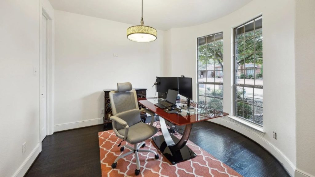 Bright home office with curved windows and modern desk setup.