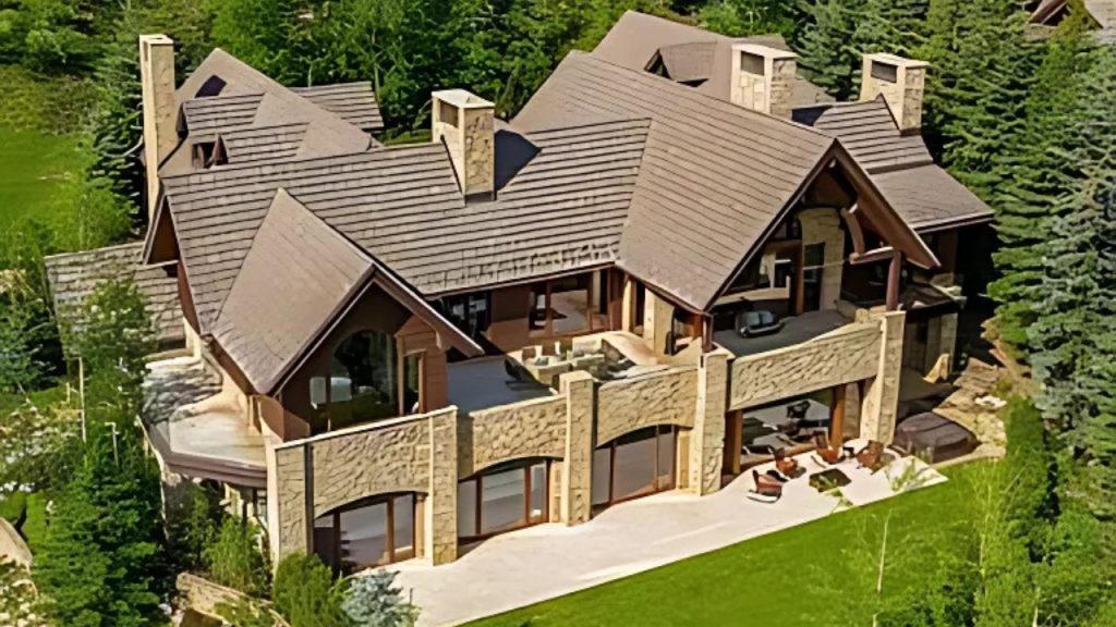 Spacious outdoor patio with stone and wood elements, overlooking lush greenery.