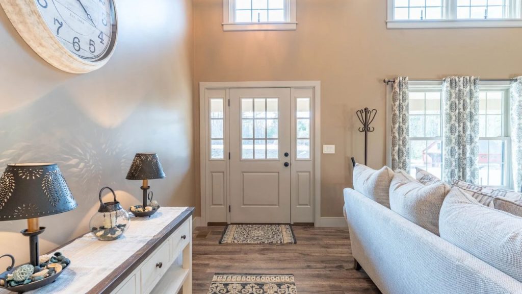 Bright and inviting entryway with double doors, wood flooring, and cozy decor.