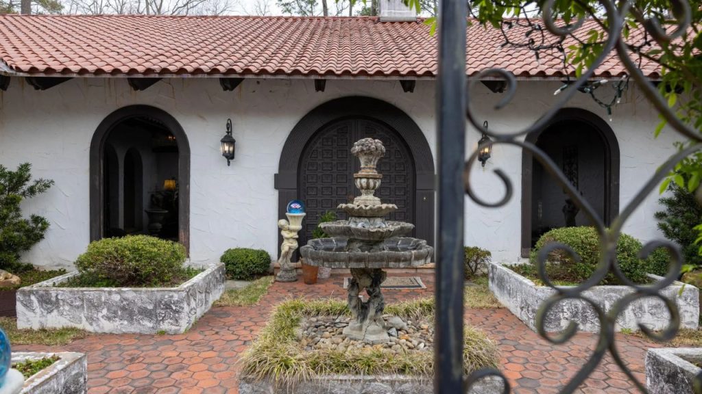 Spanish-style courtyard with a fountain and arched entryways.