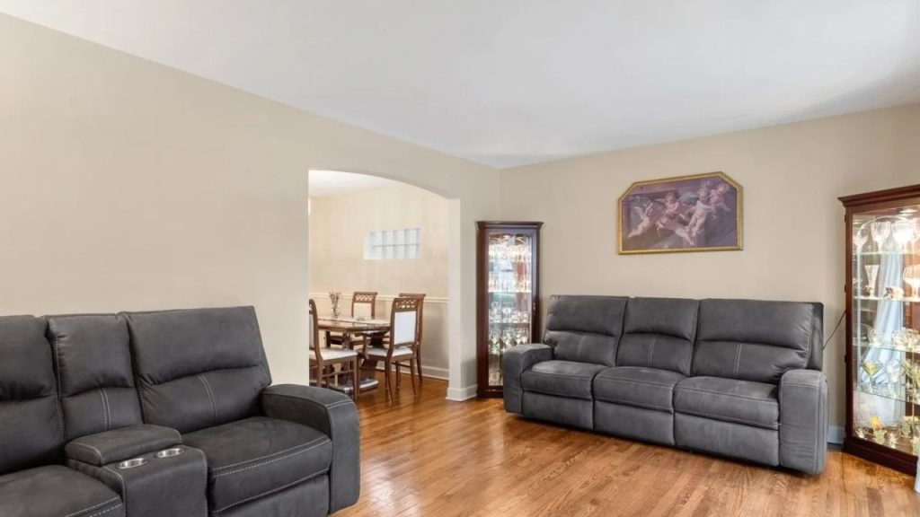 Cozy living room with gray recliners, hardwood floors, and an open dining area.
