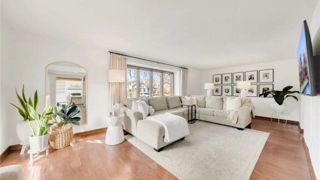Cozy neutral-toned living room with bay window and large sectional.