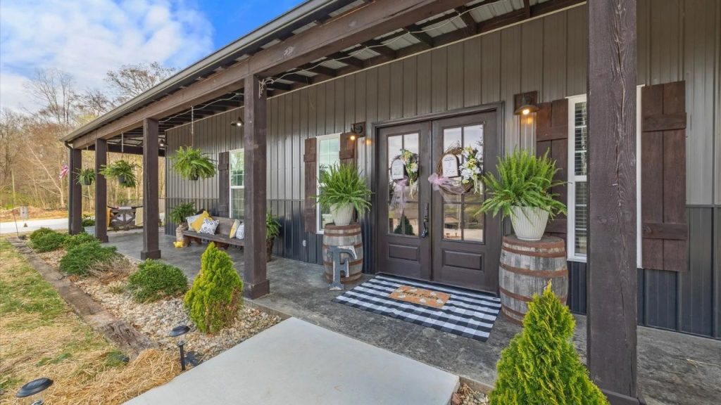 Rustic front porch with wooden beams, greenery, and a cozy seating area.