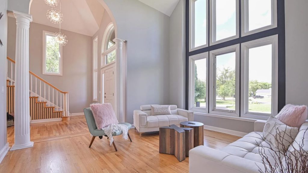 Bright living room with tall windows and cozy seating.