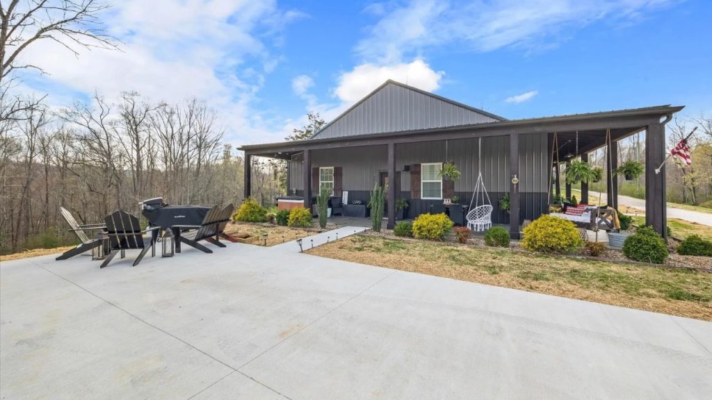Rustic home with a large porch, firepit area, and scenic woodland views.