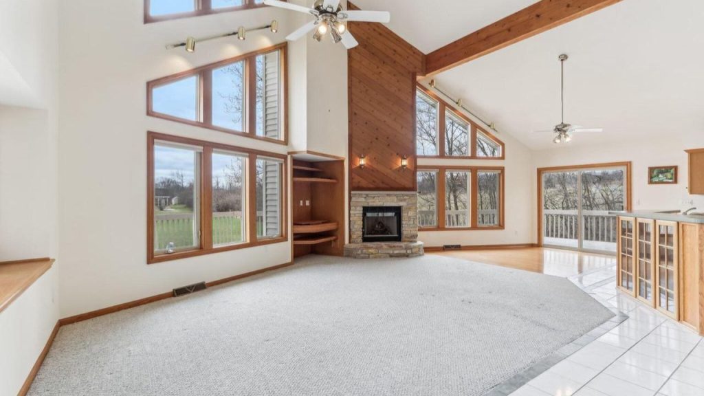 Vaulted living room with large windows, fireplace, and open floor plan.