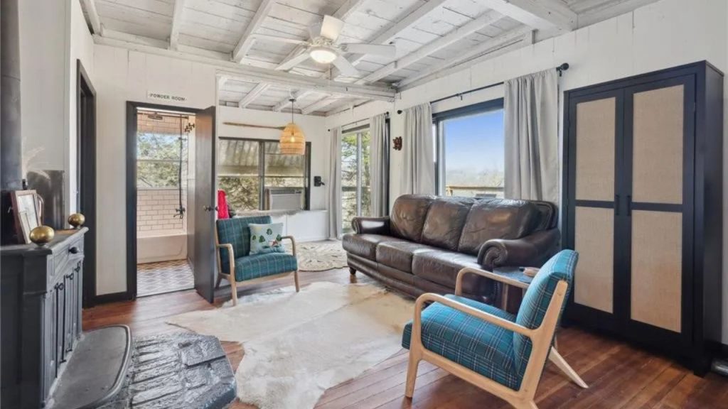 Bright living room with wood accents, cozy seating, and large windows.