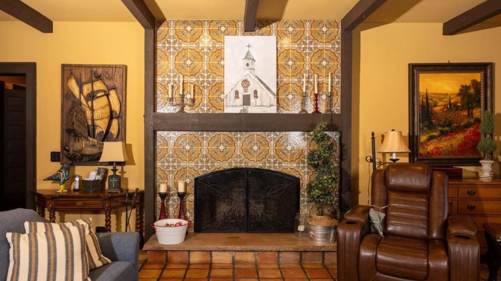 Elegant fireplace with decorative tiles, vintage artwork, and a mix of classic furniture and décor.