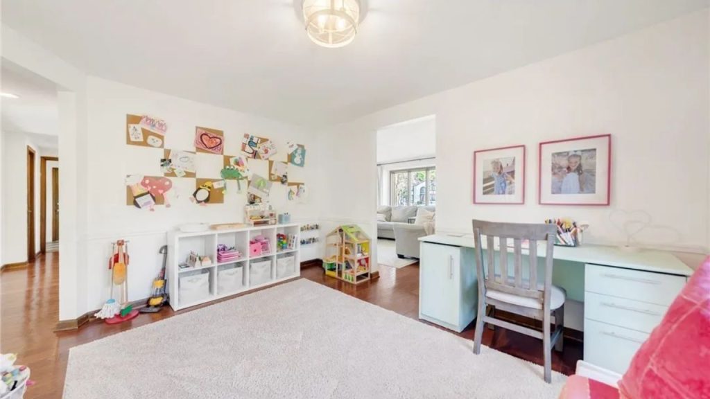 Bright kids’ playroom with art, toys, and a small desk.