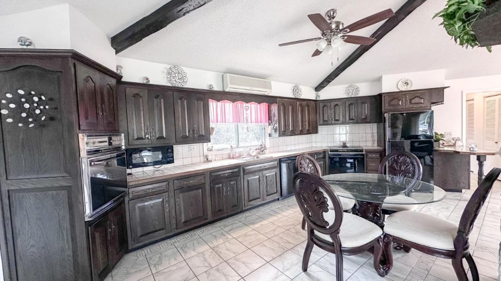 Traditional kitchen with dark wood cabinets and tile flooring.