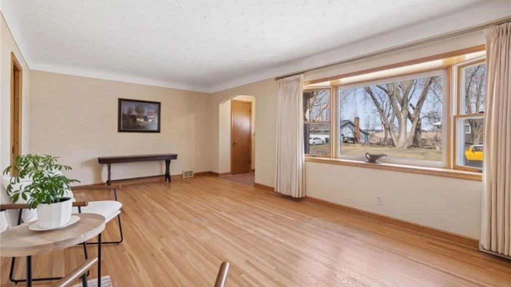 Bright, open living room with hardwood floors and large bay window.