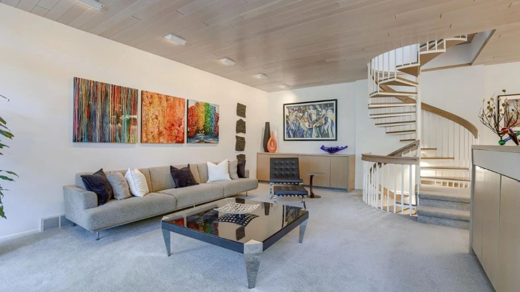 Lounge area with colorful art and a spiral staircase.