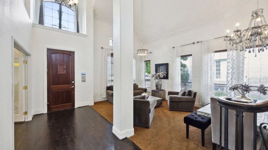 Bright entryway with tall ceilings and a cozy, elegant living room off to the side.