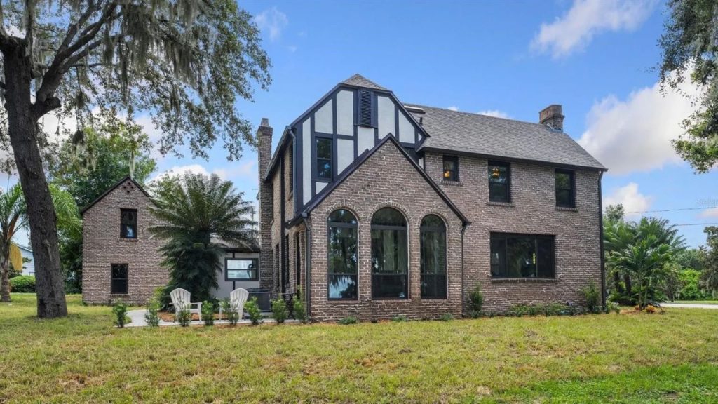Tudor-style brick house with arched windows and a cozy patio.