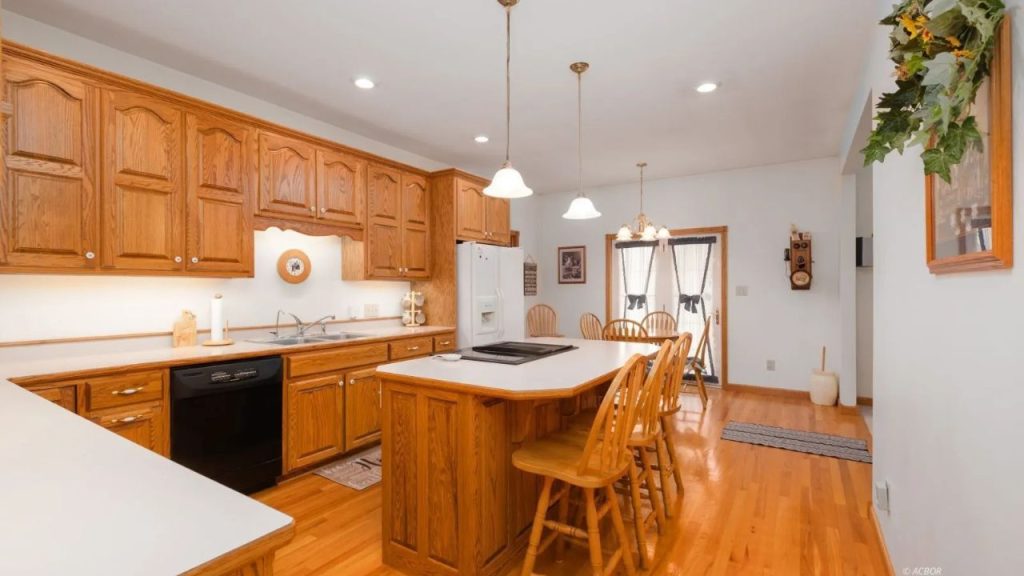 Bright kitchen with oak cabinets, an island cooktop, and a cozy dining space.