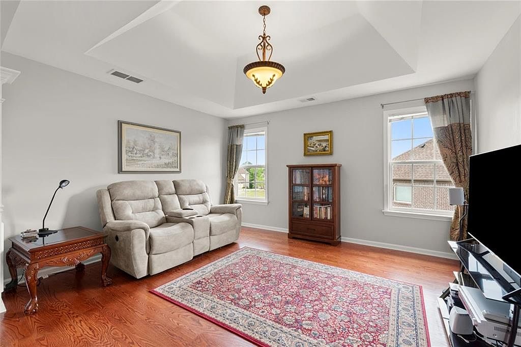Living room with beige reclining sofa and traditional wooden furniture