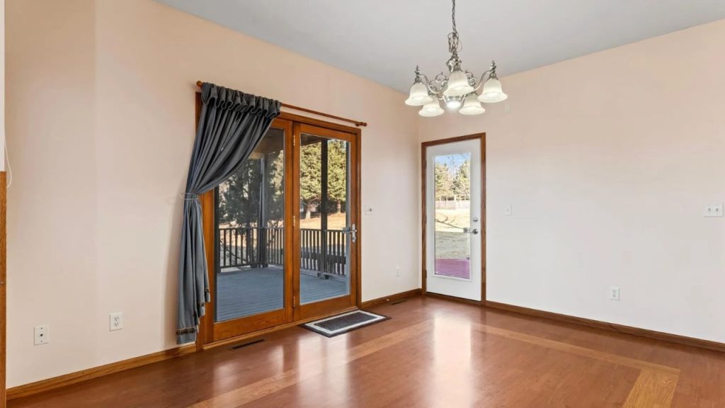 Sunny corner with wood floors, chandelier, and porch access.