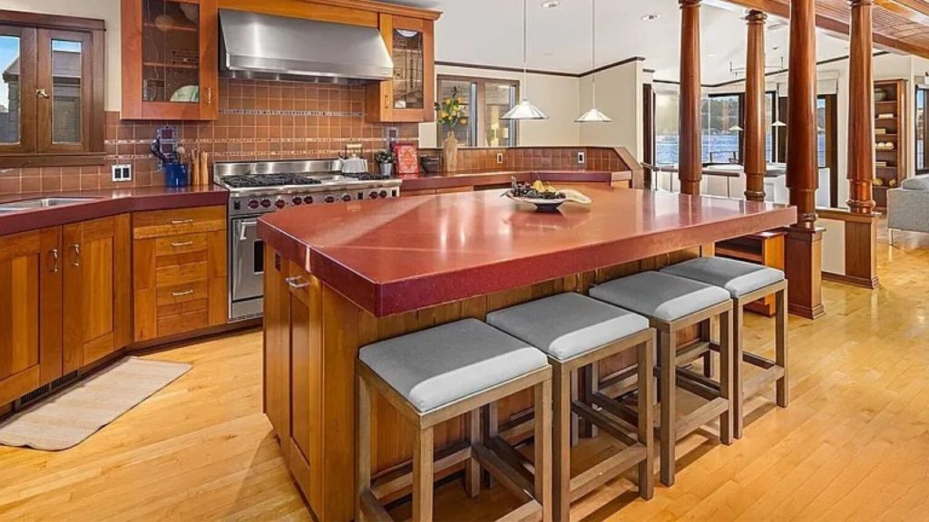 Spacious kitchen with red countertops, wood cabinets, and island seating.