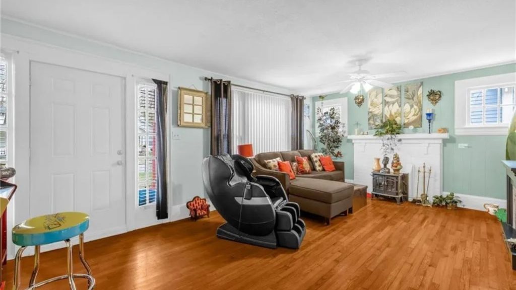 Bright living room with green walls, sectional sofa, and a black massage chair.