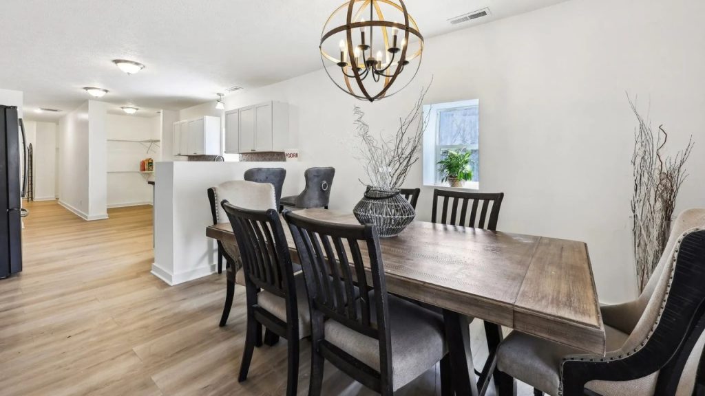 Dining room with wood table, mixed chairs, and open layout to kitchen.