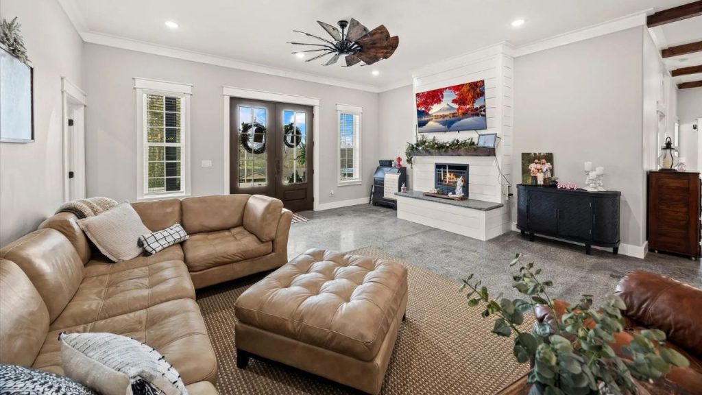 Cozy living room with a sectional, fireplace, and farmhouse-style decor.