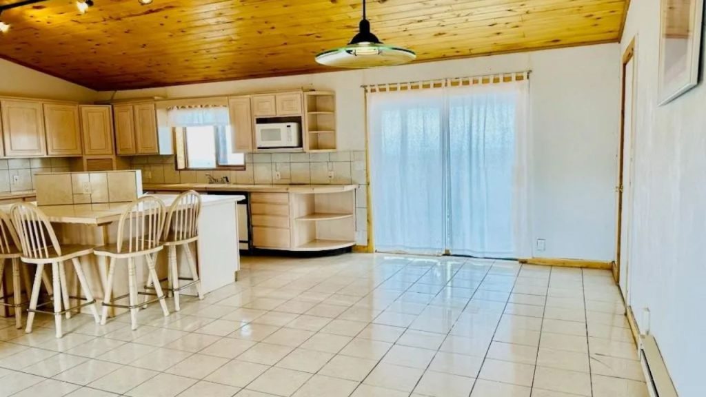 Bright kitchen with wood cabinets, island seating, and sliding glass doors.