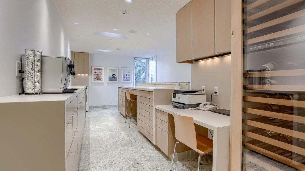 Modern galley kitchen with built-in workspace and soft wood tones.