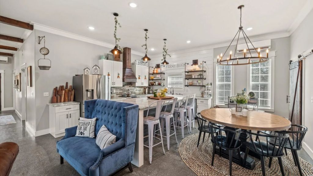 Bright farmhouse kitchen and dining area with a large island, rustic décor, and cozy seating.