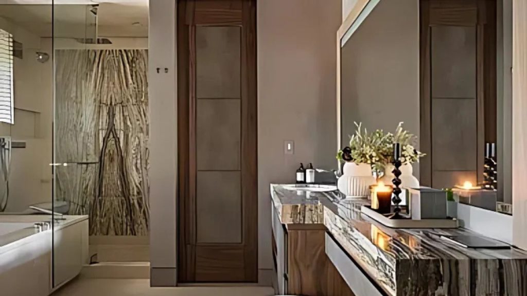 A luxurious bathroom with a marble vanity, candles, and a spacious shower.